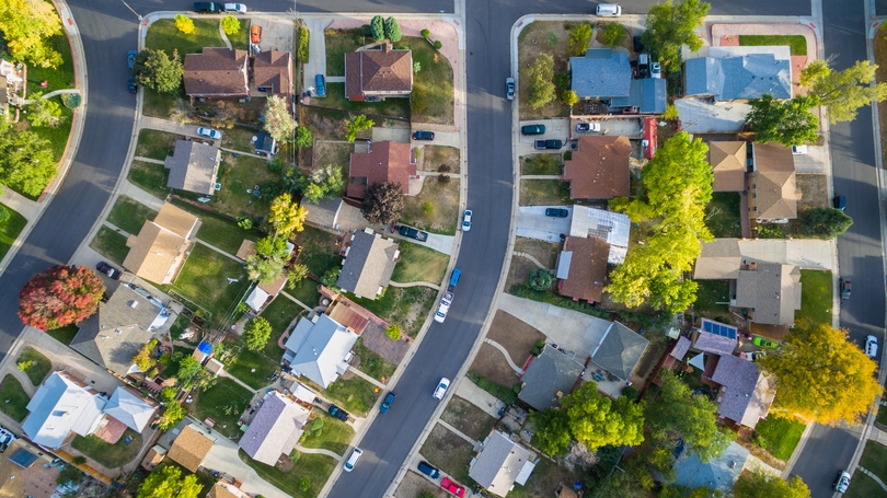 Aerial view of a suburban neighbourhood of detached houses and tree-lined streets